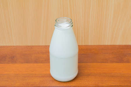 bottle of milk isolated on wood backgroundの写真素材