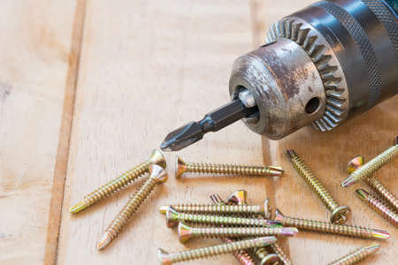 Screw and electric drill on woodの写真素材
