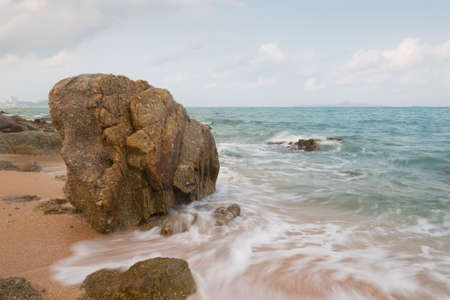 Big rock on sand and sea with low speed shutterの写真素材
