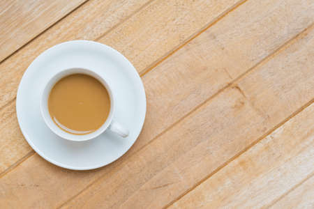 Top view of hot coffee on white cup on wood textures is diagonal for backgroundの写真素材