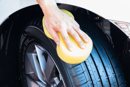Cleaning car wheel, wiping tire after cleaning on car washing.の写真素材