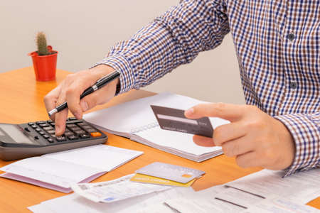 Man using calculator to calulate and payment credit card, tax and credit card. Payment credit card,...