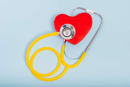 Red heart, Yellow Stethoscope on blue background with Copy space. Medical concept, Health care concept.の写真素材