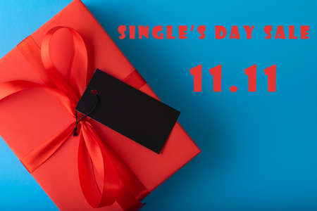 11.11 single's day sale concept. Online shopping concept. Red gift with Black tag paper on blue...