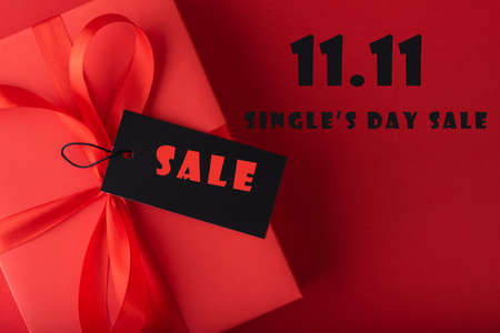 11.11 single's day sale concept. Online shopping concept. Red gift with Black tag paper on blue...
