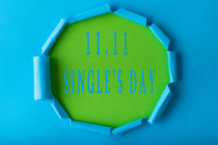11.11 Single day sale. Blue circle torn paper with 11.11 Single days sale on green color backgroundの写真素材