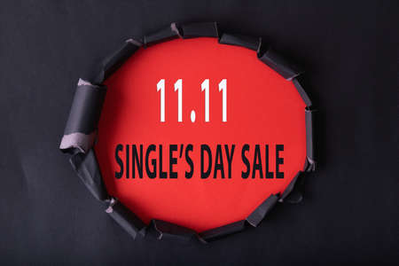 11.11 Single day sale. Black circle torn paper with 11.11 Single days sale text on red color backgroundの写真素材