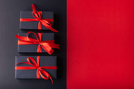 3 black box with red ribbon on half black color background and half red color background. 11.11 single day, Monday, Friday sale conceptの写真素材