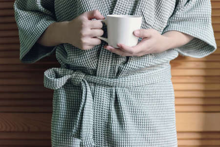 holding a mug in green robeの写真素材