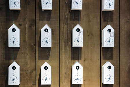 white bird clocks on wooden wall in a rowの写真素材