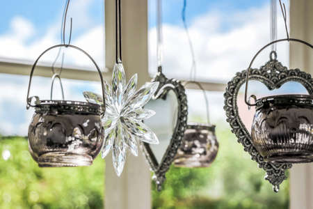 hanging craft decorations beside windowの写真素材