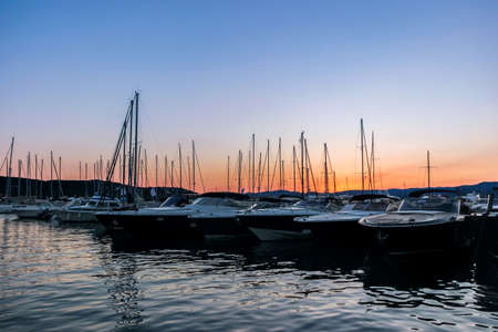 yachts on water at pier at sunsetの写真素材