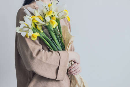 woman holding yellow iris flower bouquetの写真素材