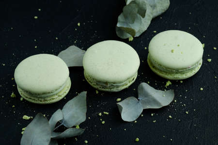 Tasty sweet green macarons cakes on dark background, dark moodの写真素材