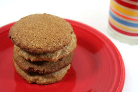 Stack of 4 cookies on red plate with glass of milk for Santaの写真素材