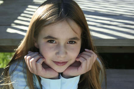 Pre teen girl sitting on steps with chin in handsの写真素材
