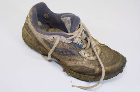 Dirty old grass stained lawn mower worn out sneakerの写真素材