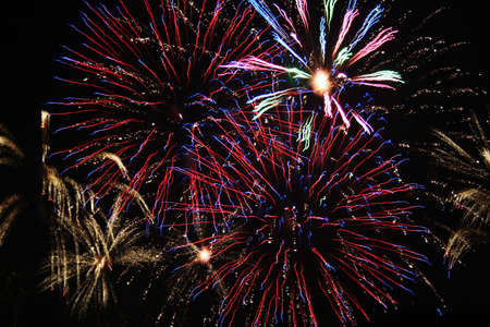 Colorful fireworks set off in night sky celebrating holidayの写真素材