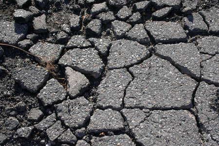 Cracked broken asphalt pavement in parking lotの写真素材