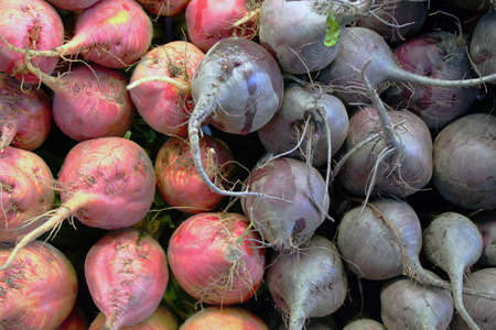 Red and purple beets piled up at farmer's marketの写真素材