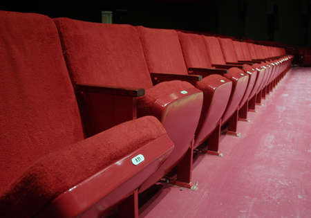 Red theater seats in small theater front row