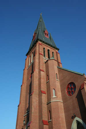 Tall catholic church steeple against blue skyの写真素材