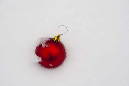 single red Christmas ornament in fresh new snow with snow detailの写真素材