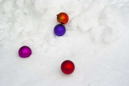 Colorful Christmas ornaments tossed into fresh snowfallの写真素材