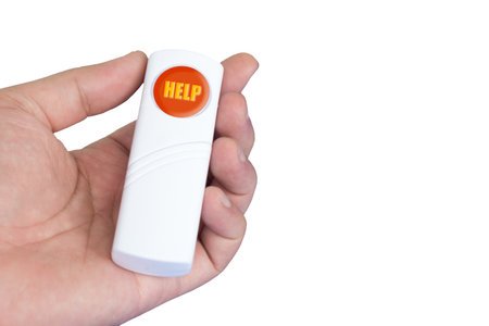 A person holds a handheld help button in red with yellow label,  commonly used for emergencies and...