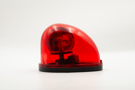 The close-up side view of red emergency light isolated on white background, emphasizing its...