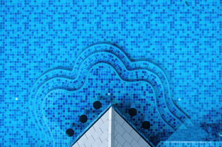 This aerial view showcases a beautifully designed pool with a distinct shape and vibrant blue tiles. The clear water invites relaxation and enjoyment.の写真素材