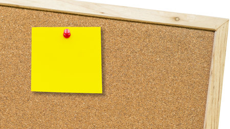 A bright yellow post it note is prominently displayed on a cork board, showcasing a helpful reminder or message in an organized workspace.の写真素材