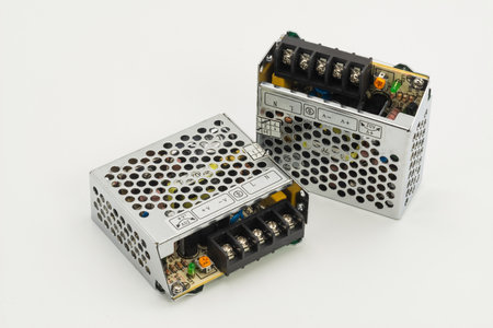 Two compact switching power supplies are displayed, showcasing their intricate internal circuitry...