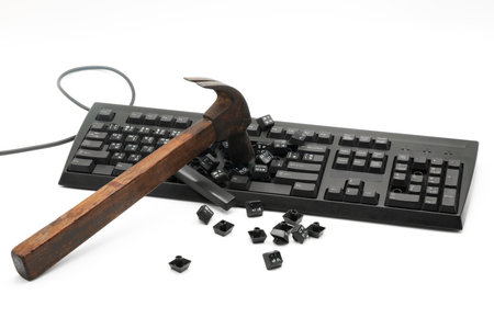 A hammer strikes a keyboard, shattering keys onto the surface. The moment captures a determined...