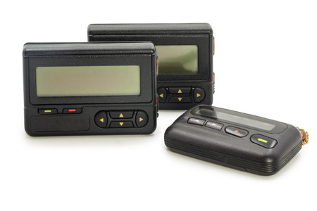 Three old fashioned pagers are displayed together, highlighting their design and buttons, reminiscent of 1990s communication.の写真素材