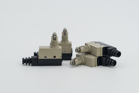 Various industrial limit switches are arranged on a plain surface, showcasing their design and...