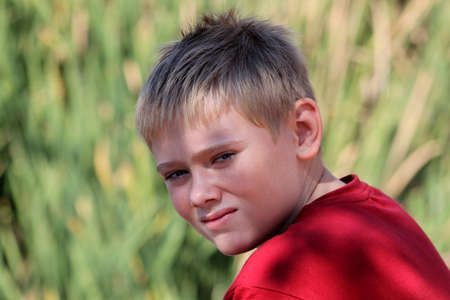 Close-up of Calm Attractive Young Blond Boy in Nature