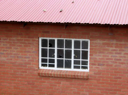 Vandalised Abandoned Red Brick Building with Broken Windows 