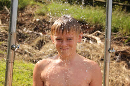 Portrait of Smiling Boy Washing Under Open Beach Showerの写真素材