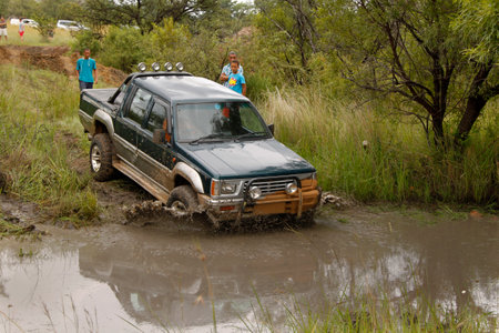 BAFOKENG - MARCH 8: Viridian Green Mitsubishi Colt Rodeo Twin Cab crossing muddy pond obstacle at...