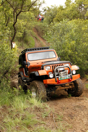 BAFOKENG - MARCH 8: Crush Beige Jeep Wrangler Off-Roader V8 crossing obstacle at Leroleng 4x4 track on March 8, 2014 in Bafokeng, Rustenburg, South Africaのeditorial素材