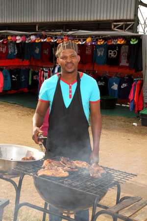 RUSTENBURG, SOUTH AFRICA - MAY 25: African man busy with barbecue  at Rustenburg Fair on May 25, 2014 in Rustenburg South Africa.のeditorial素材