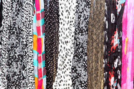 Variety of Hanging Scarves Providing Colourful Backdrop for Graphic Artistsの写真素材