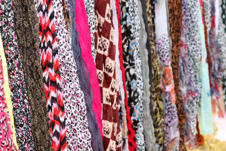 Variety of Hanging Scarves Providing Colourful Backdrop for Graphic Artistsの写真素材