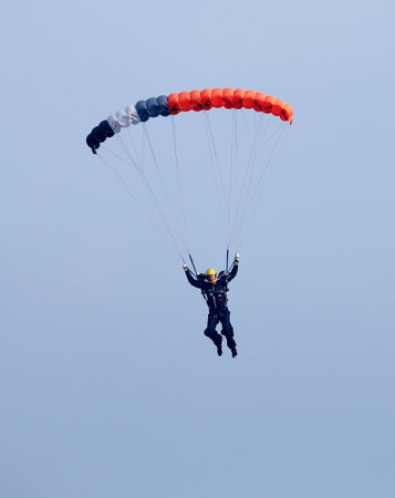 RUSTENBURG, SOUTH AFRICA - April 28, 2017: National Skydiving Championships. Male sky diver with brightly coloured open parachute gliding in airのeditorial素材