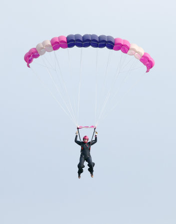 RUSTENBURG, SOUTH AFRICA - April 28, 2017: National Skydiving Championships. Female sky diver with brightly coloured open parachute gliding in airのeditorial素材