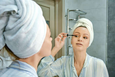 Reflection in the mirror Woman make up with mirror in the bathroom.の写真素材