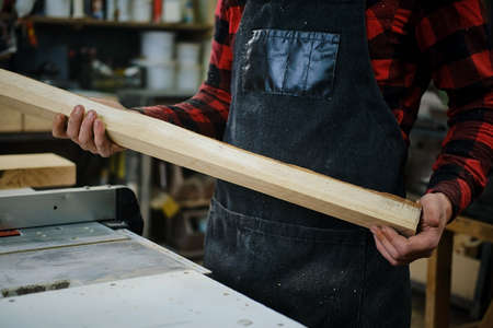 A worker holds a cutting board in a wood workshop. Close upの写真素材