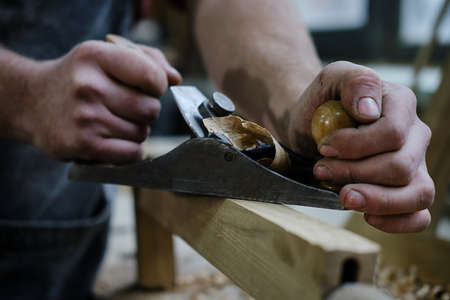 Carpenters experienced wood is using spokeshave to decorate the furniture.の写真素材