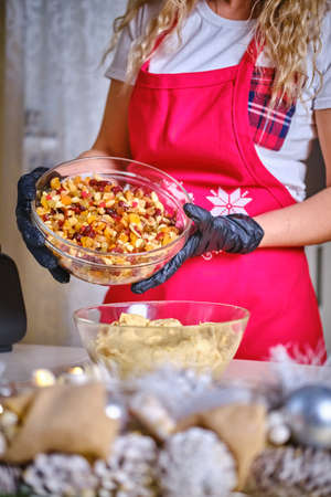 Female hands holding a bowl Ingredients nuts and raisins for cookies, Version 2の写真素材